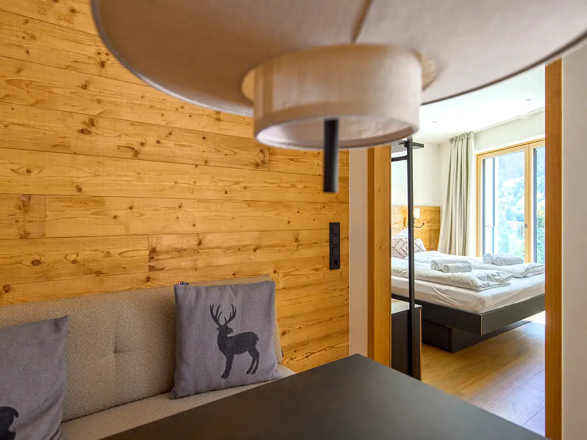 Wohn- und Schlafbereich mit Holzvertäfelung und gemütlicher Sitzecke im Apartment HANSI im Chalet H