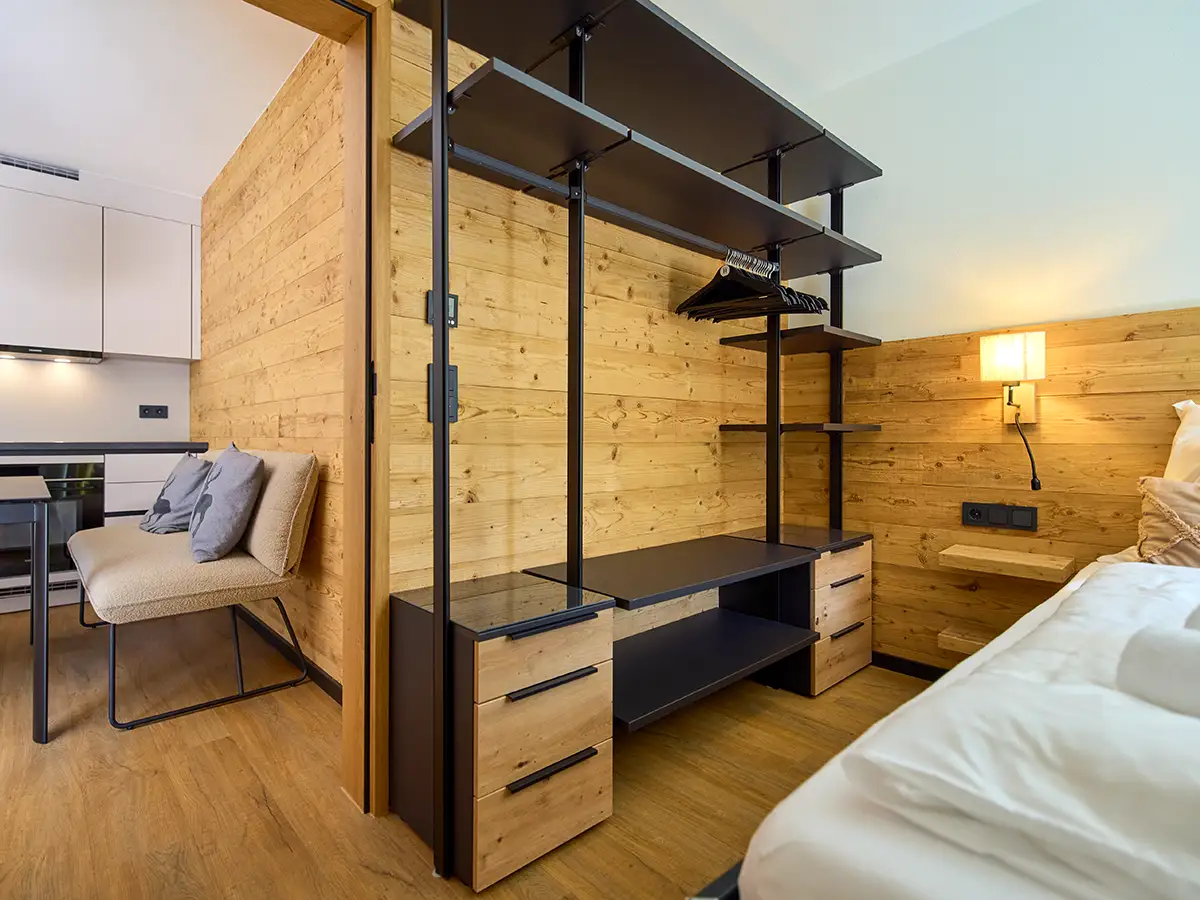 Kombinierter Ess- und Schlafbereich mit markantem Holzregal im Apartment HANSI im Chalet H