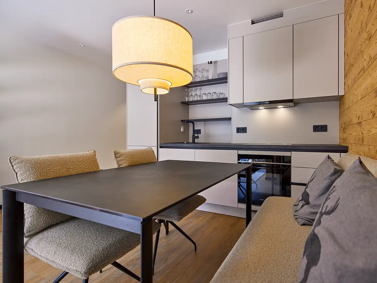 Moderne Küche mit Essplatz und freundlicher Beleuchtung im Apartment HANSI im Chalet H