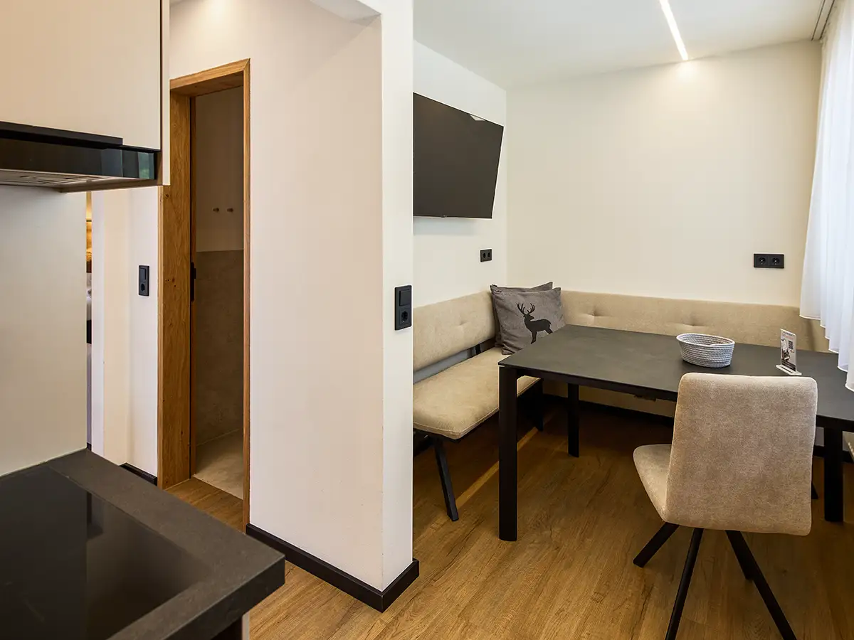 Kompakter Essbereich mit bequemer Sitzbank und moderner Gestaltung im Apartment HARMONY im Chalet H