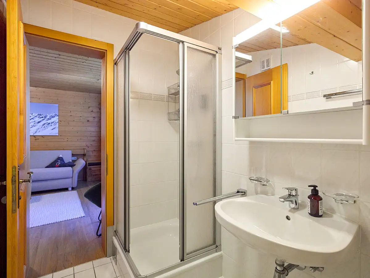 Modernes Badezimmer mit Glasdusche und warmen Holzelementen im Apartment HEAVEN im Chalet H