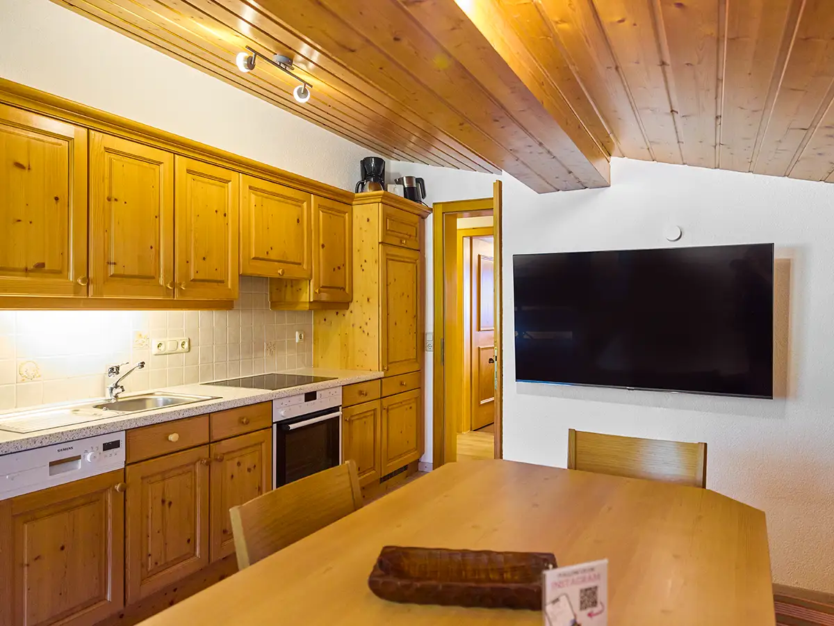 Gemütliche Küche mit Holzfronten, Essplatz und alpinem Ambiente im Apartment HEAVEN im Chalet H