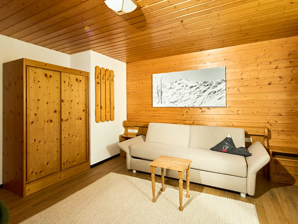 Wohnbereich mit viel Holz, Sofa und gemütlicher Beleuchtung im Apartment HEAVEN im Chalet H