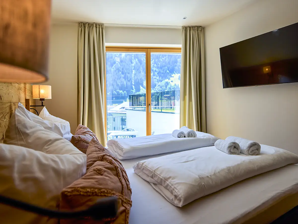 Helles Doppelzimmer mit großen Fenstern und Bergpanorama im Apartment HEIDI im Chalet H
