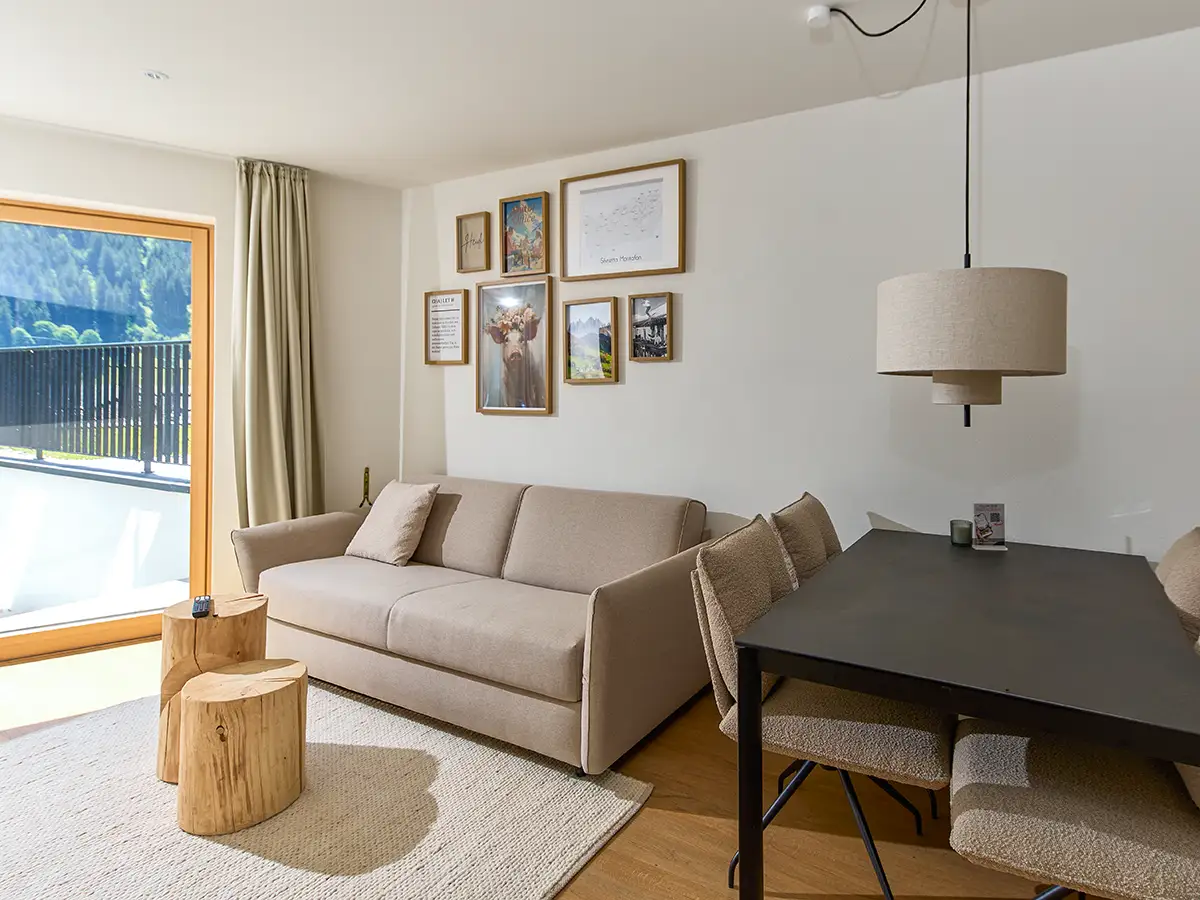 Helles Wohnzimmer mit Sofa, Bildern und moderner Stehleuchte im Apartment HEIDI im Chalet H