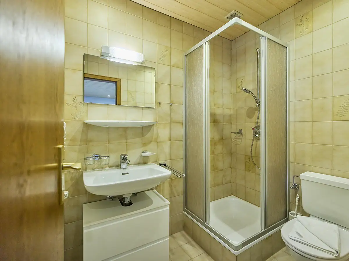 Helles Badezimmer mit Waschtisch und Glasdusche im Apartment HOME im Chalet H
