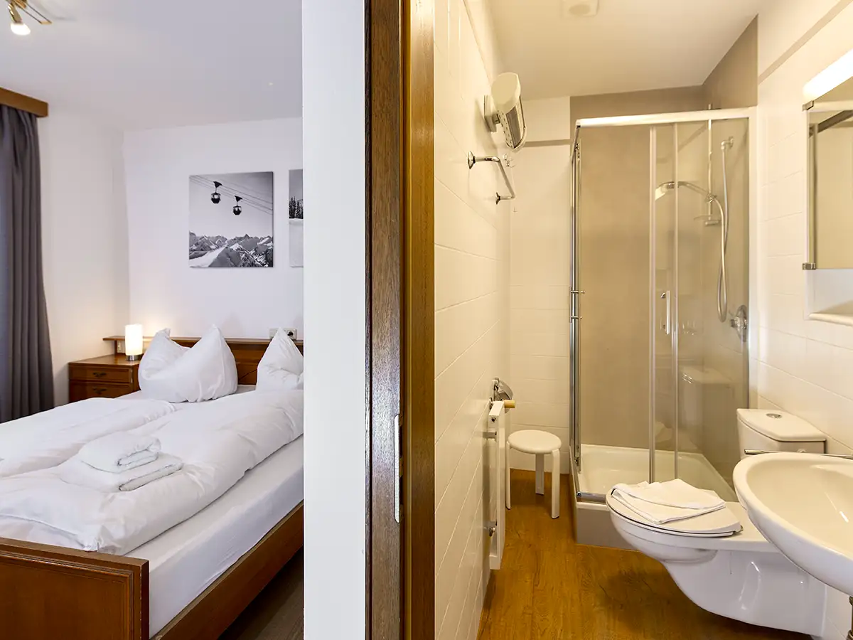 Modernes Bad mit bodengleicher Glasdusche neben dem Schlafzimmer im Apartment HOME im Chalet H