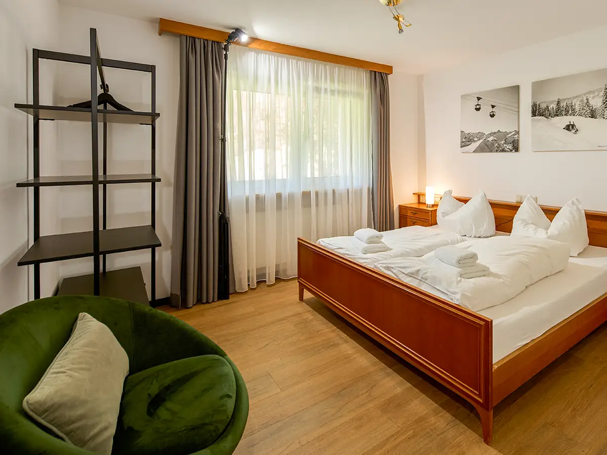 Doppelzimmer mit warmen Textilien und offener Ablage im Apartment HOME im Chalet H