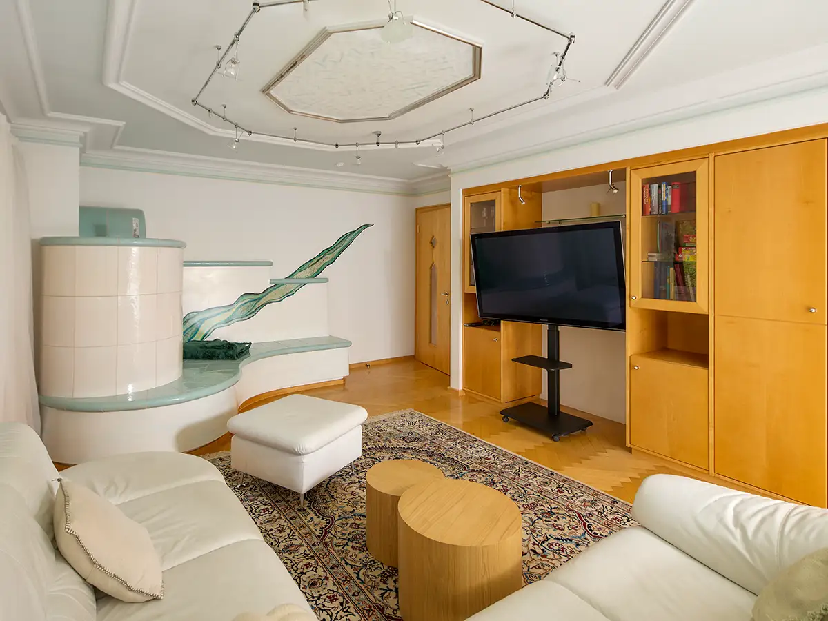 Wohnbereich mit Sofa, TV und moderner Deckengestaltung im Apartment HOME im Chalet H